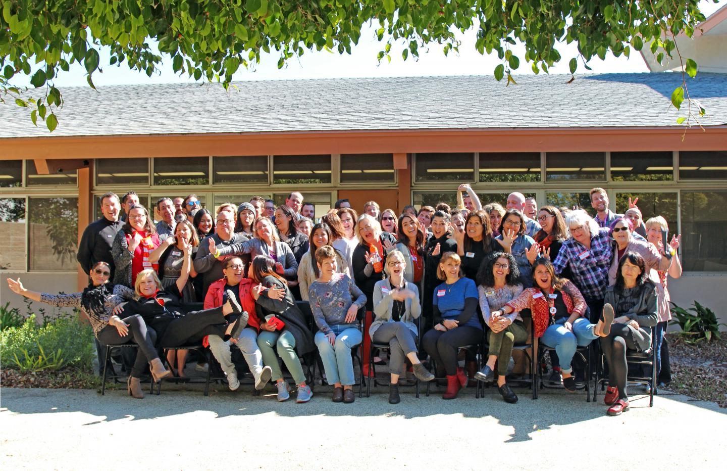 Group photo of VC employees in the Wright Event Center patio on a sunny day and being silly for the photographer.